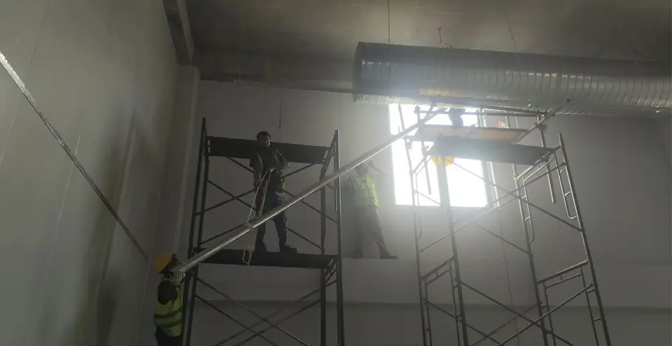 Pipe being lifted into position from scaffolding