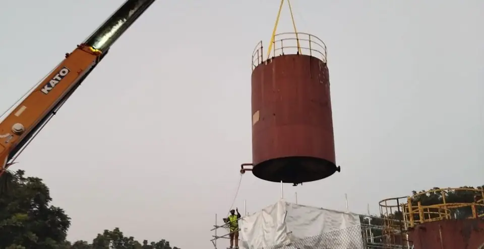 Crane lifting a heavy fuel oil storage tank