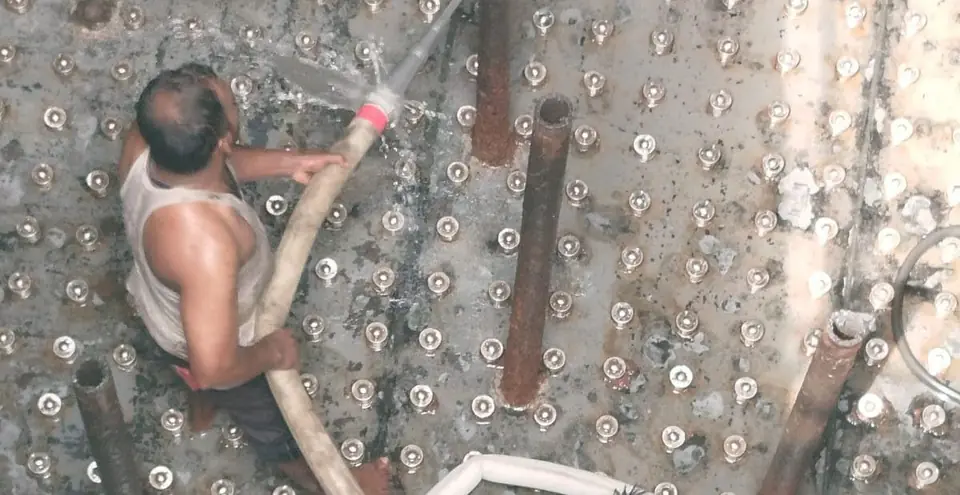 Worker washing down the new tank floor
