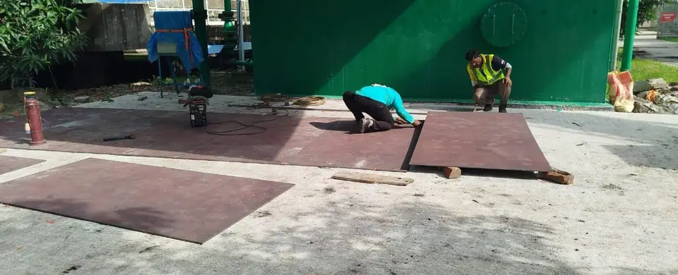 Steel plates laid out on a clear work area before welding