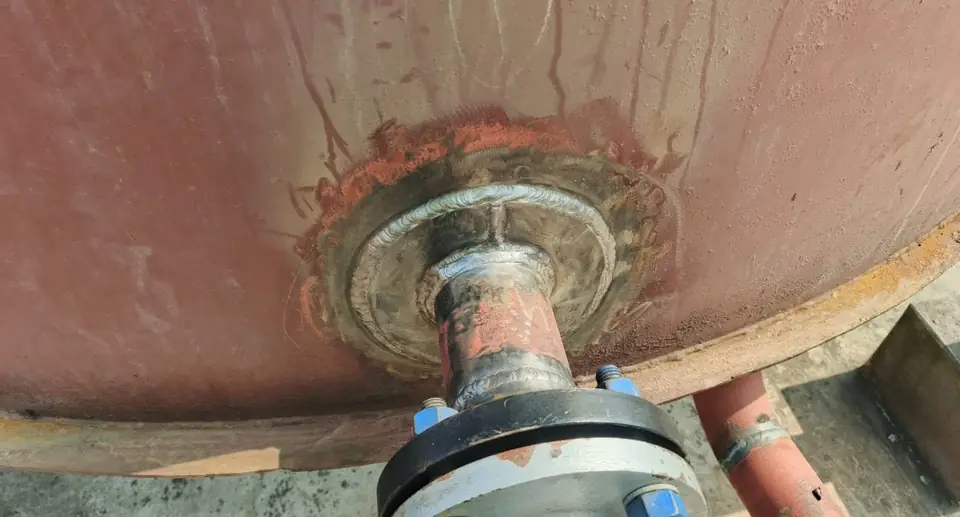 Tank shell nozzle with reinforcing pad